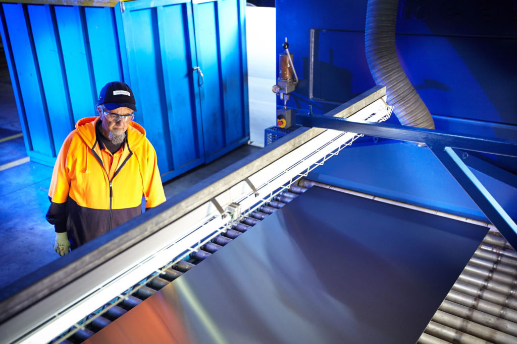 Image of a man polishing stainless steel sheets in melbourne